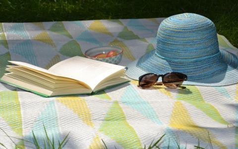 Symboldbild: Sommer - Sonnenhut, Sonnenbrille, Buch, Picknickdecke